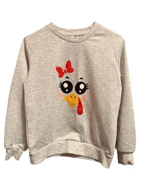 This girls' thanksgiving sweater features a playful turkey face design with big